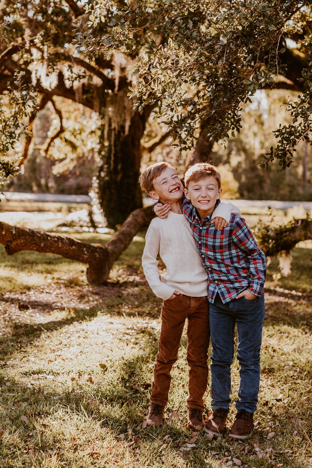 Children laughing and playing together under autumn trees.