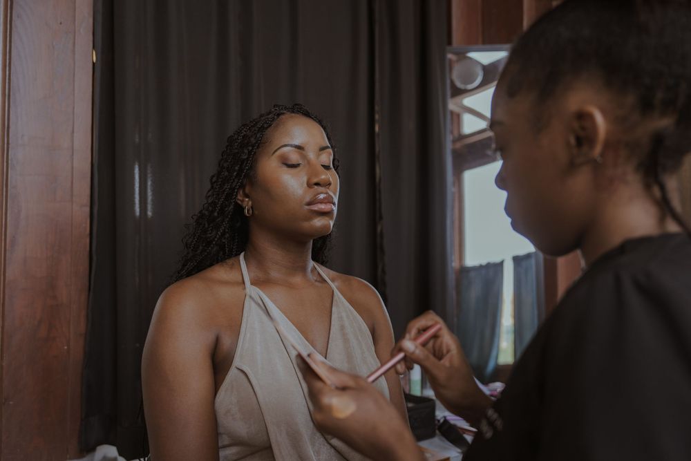 Wedding preparation moment captured in moody indoor lighting.