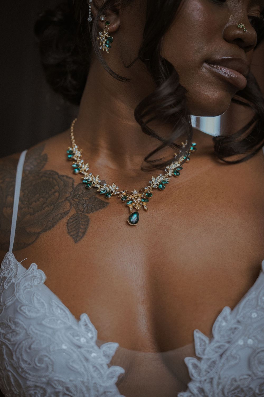 Close-up detail of an ornate silver necklace with turquoise accents on white lace.