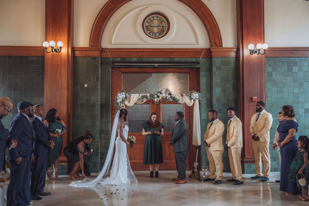 Wedding ceremony setup in an elegant hall with arched architecture and warm lighting.