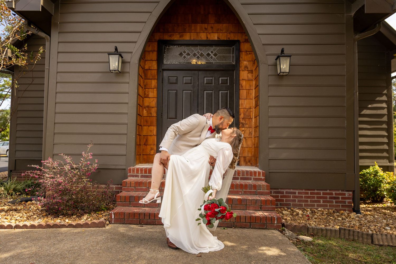 Groom dips Bride in tender moment from their wedding portraits