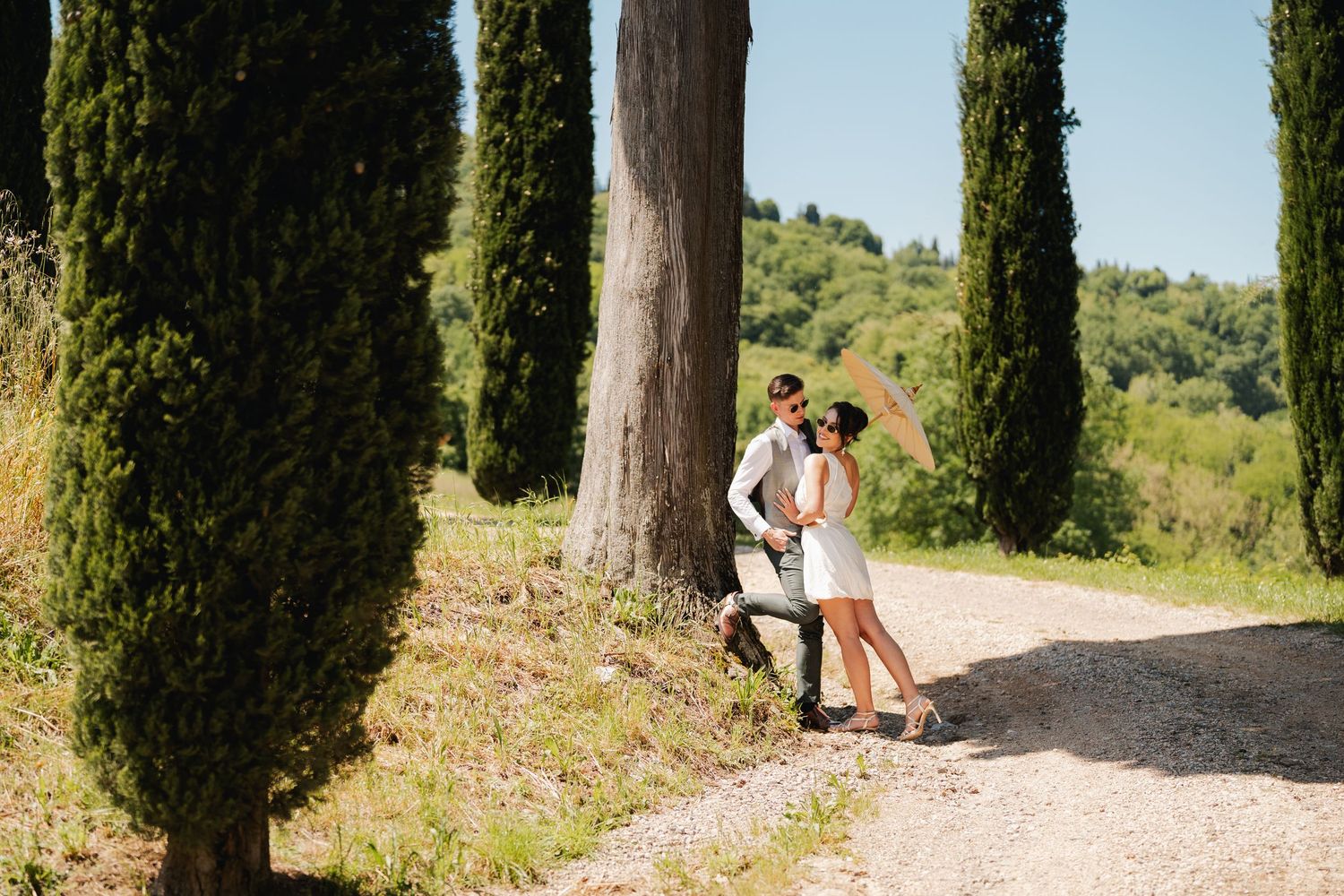 Para młoda spaceruje alejką cyprysów w Toskanii, Włochy, sesja poślubna, elegancka fotografia ślubna, fotograf ślubny za granicą, Tarnów
