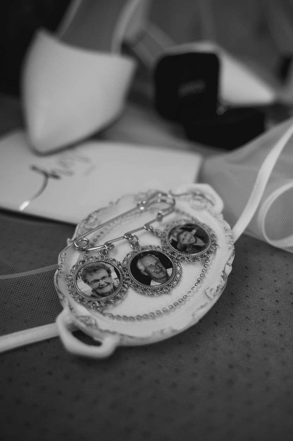 Black and white photo of vintage locket charms with decorative frames and chain details.