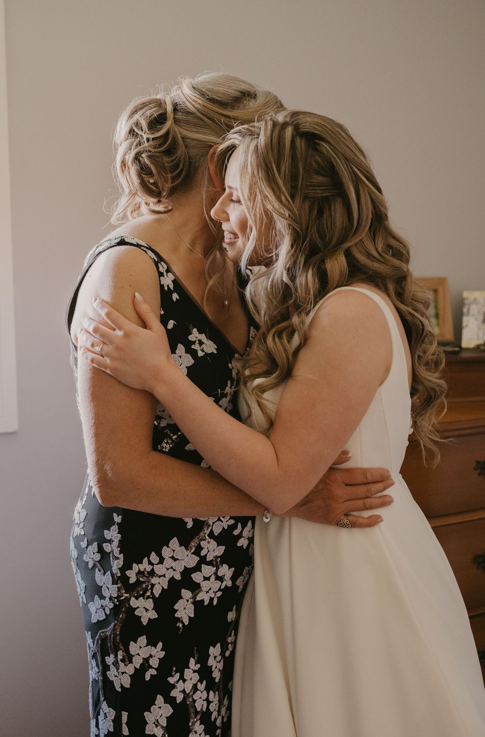 Two people sharing an emotional embrace in formal attire.