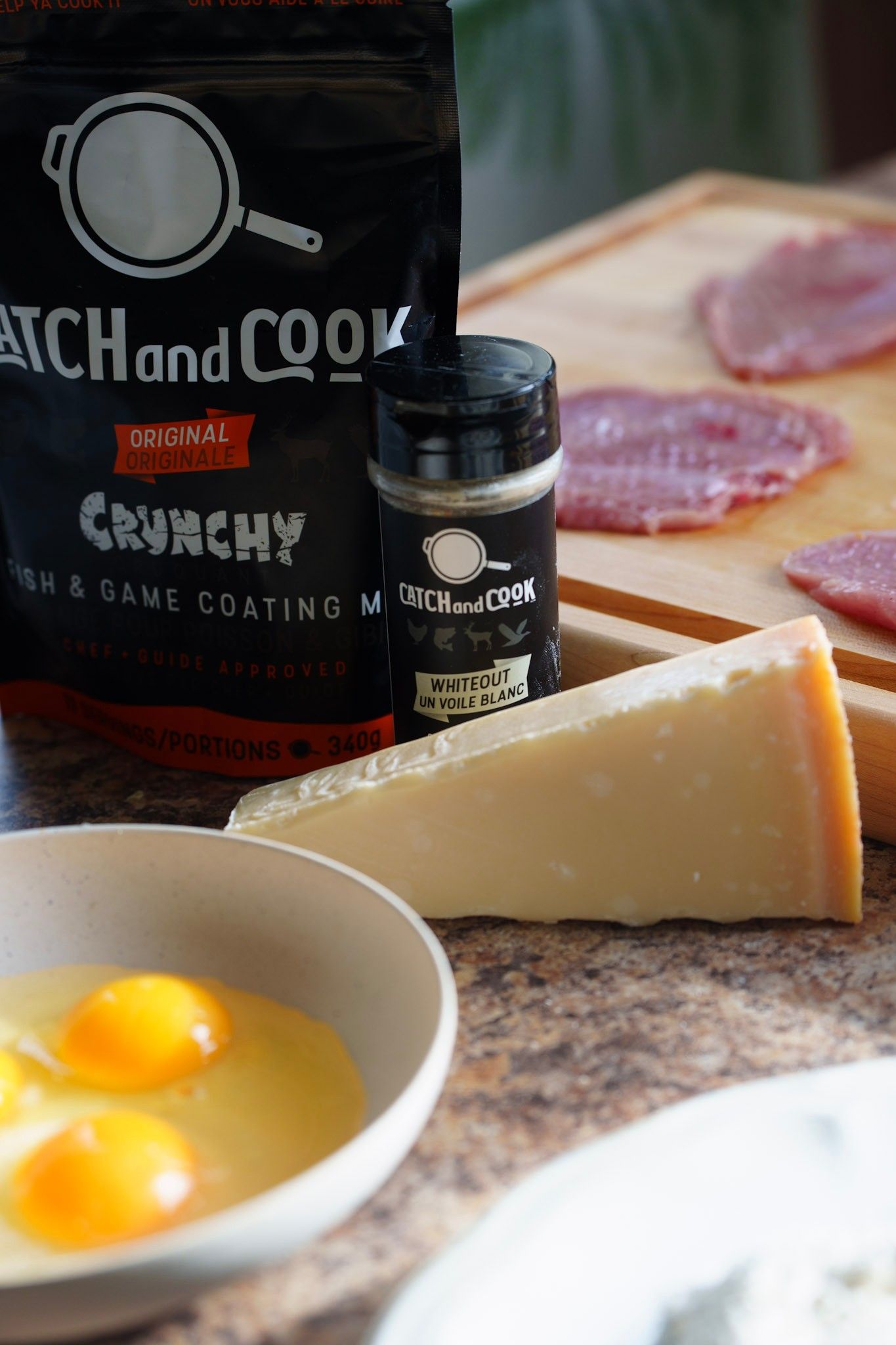 Close-up view of raw eggs and cheese ingredients on a kitchen counter with dark bottles in the background.