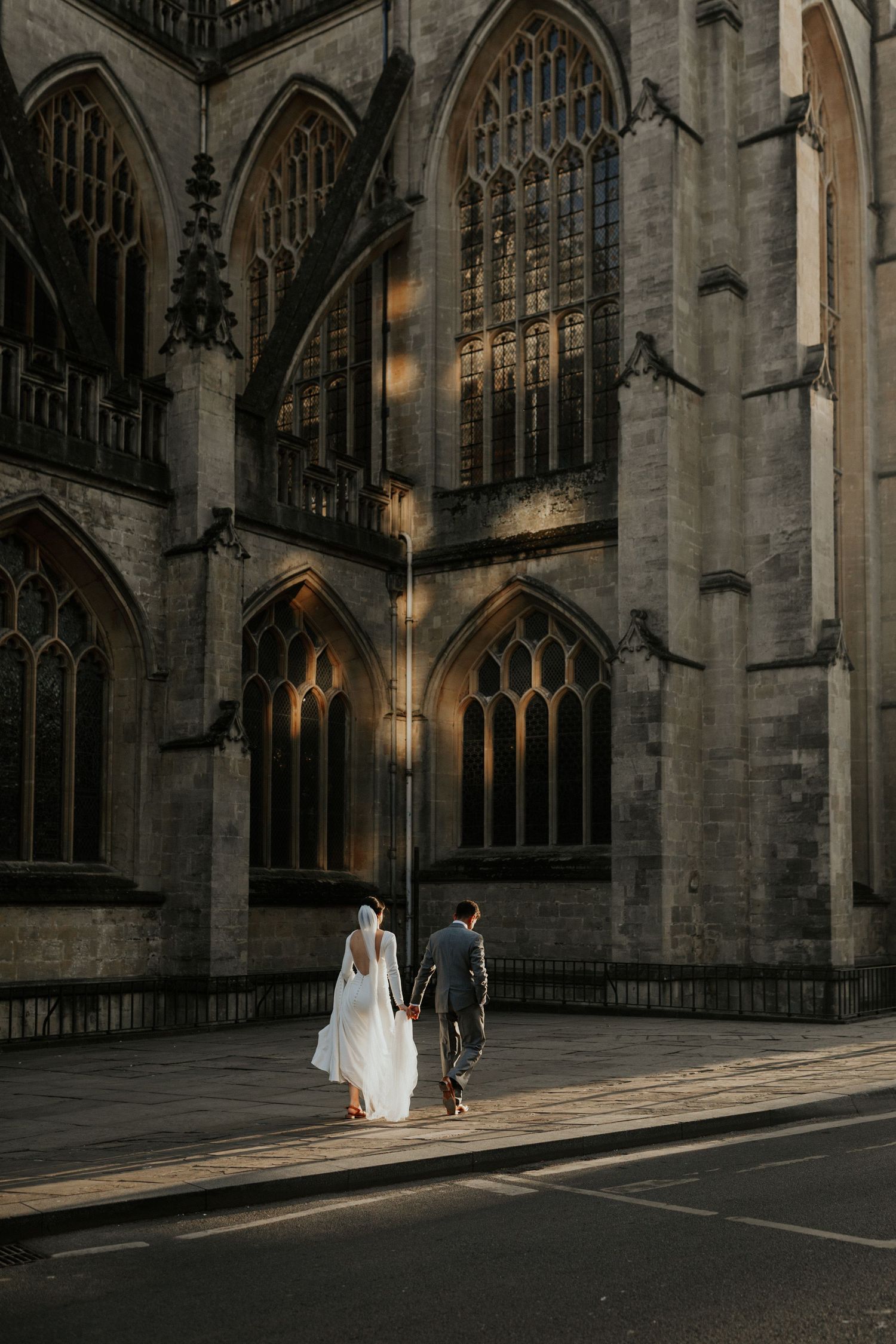 Bride and groom walking by Bath Abbey after their short wedding ceremony