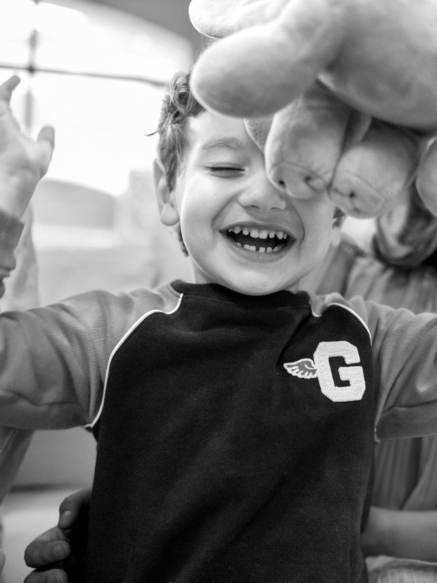 Black and white photo series showing joyful expressions and laughter in candid close-up shots.