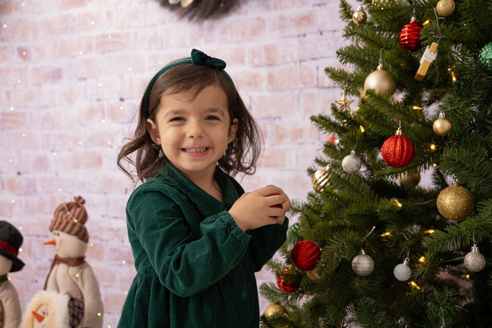 A joyful holiday moment captured near a decorated Christmas tree with wrapped presents.