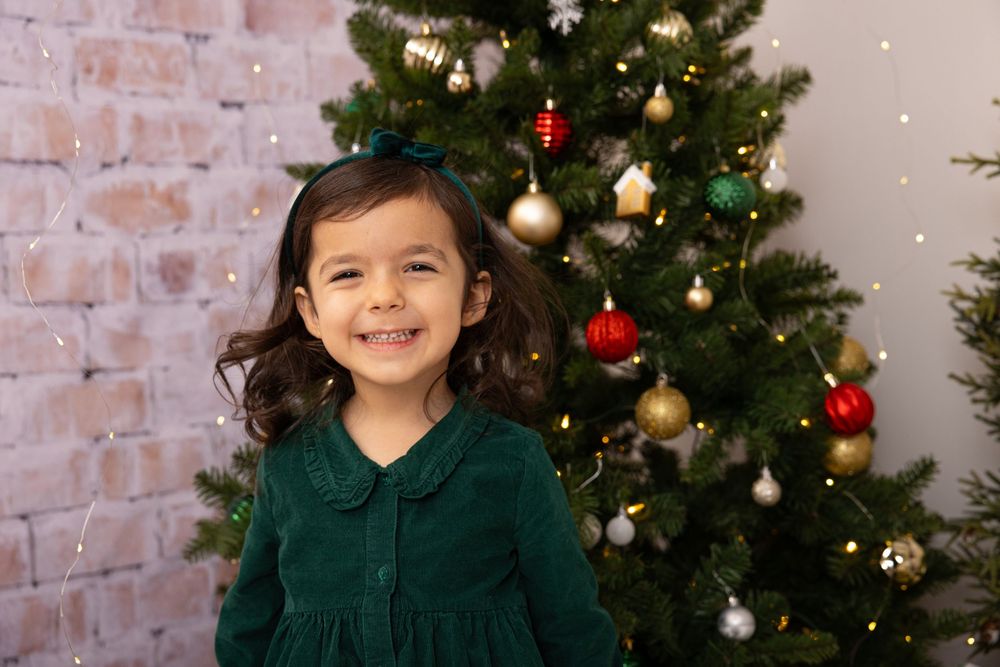A warm holiday setting with a decorated Christmas tree and exposed brick wall background.