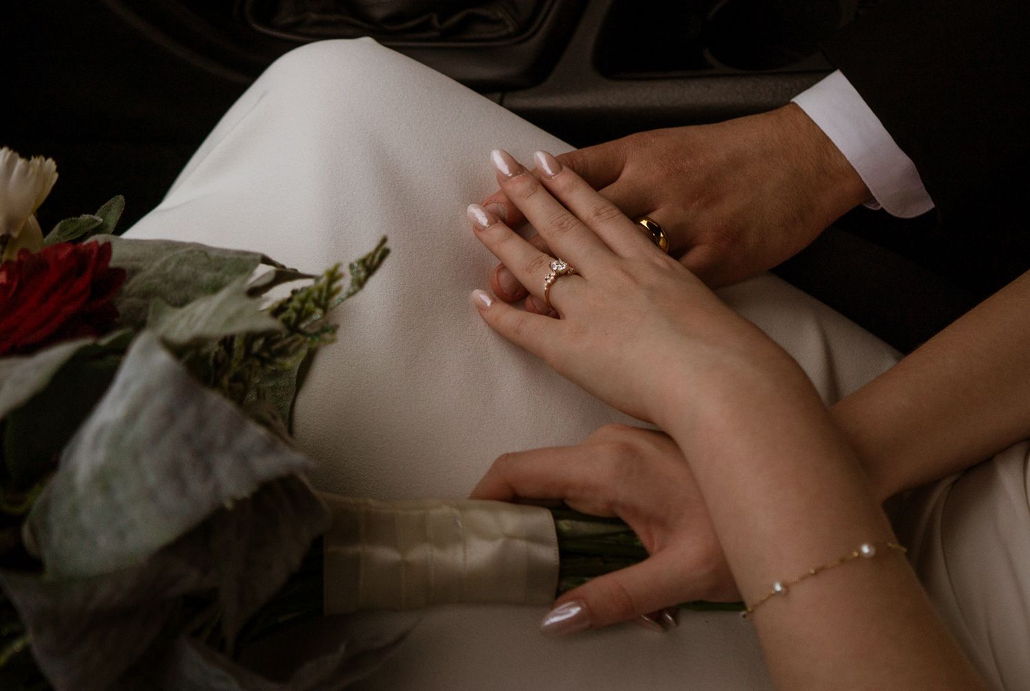 Close-up of hands gently touching in soft, intimate lighting.