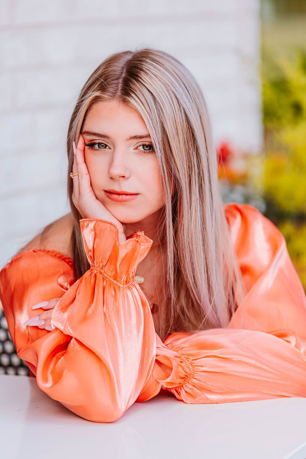 Close-up portrait in coral ruffled dress against white background.
