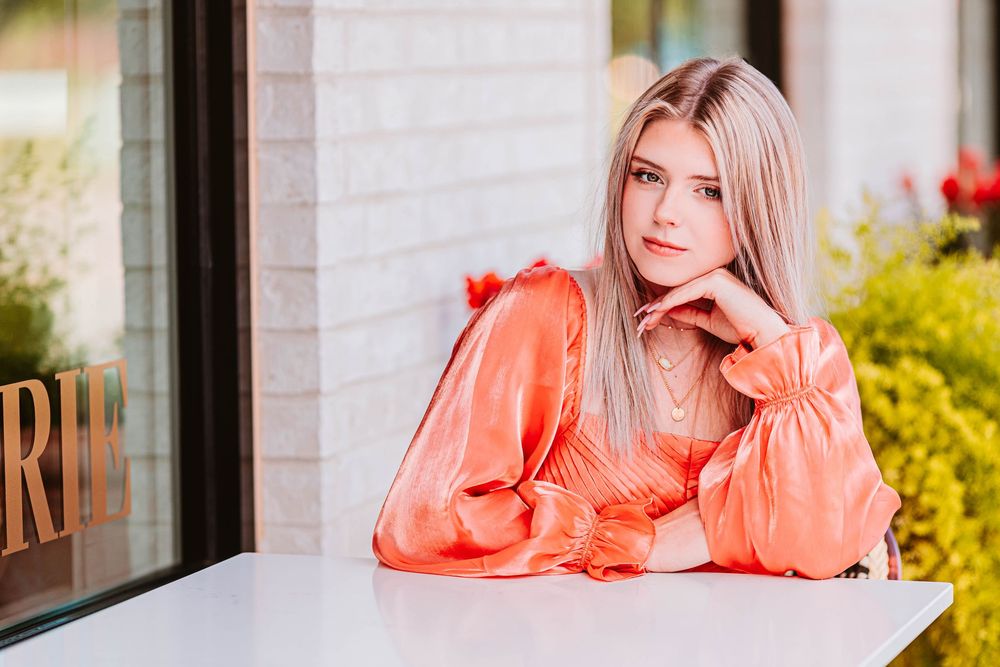 Lifestyle photo series showing someone in a bright coral dress lounging at an outdoor patio.