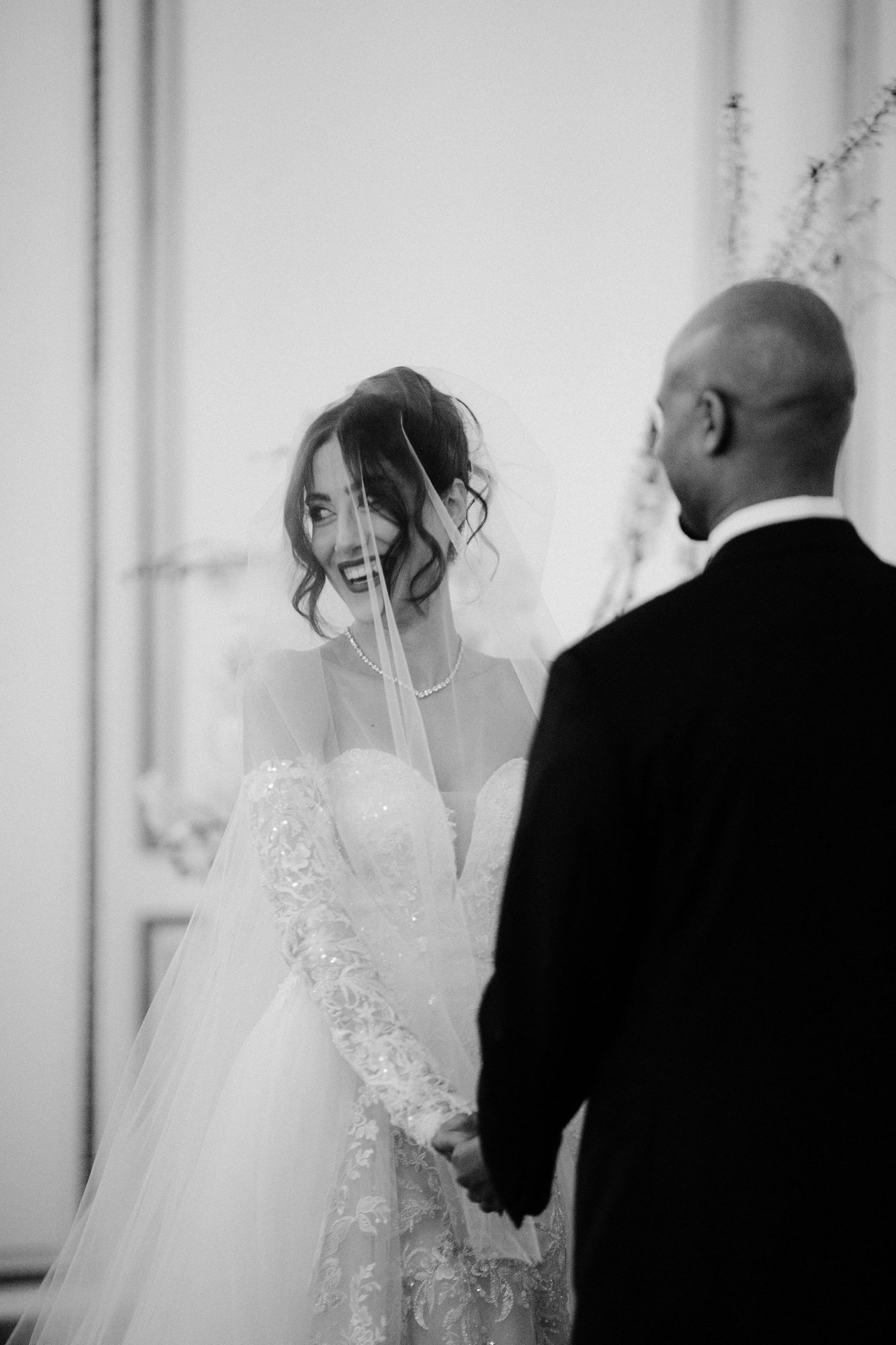 A romantic black and white wedding photo series showing intimate moments between the bride and groom.