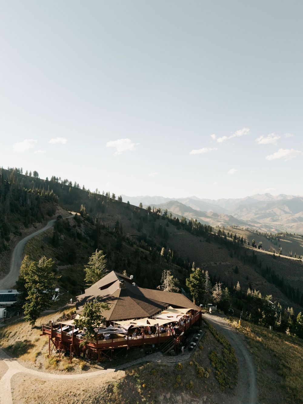 Panoramic mountain landscape view of a rustic lodge nestled among forested hills.