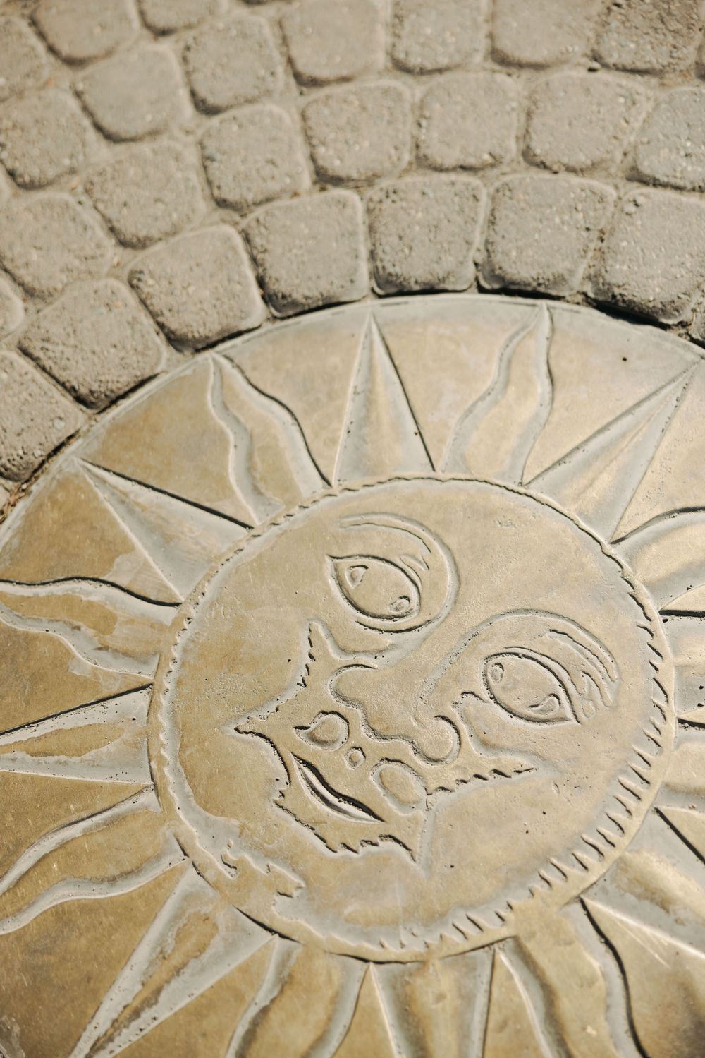 Close-up of a decorative stone sun carving with detailed rays and facial features.