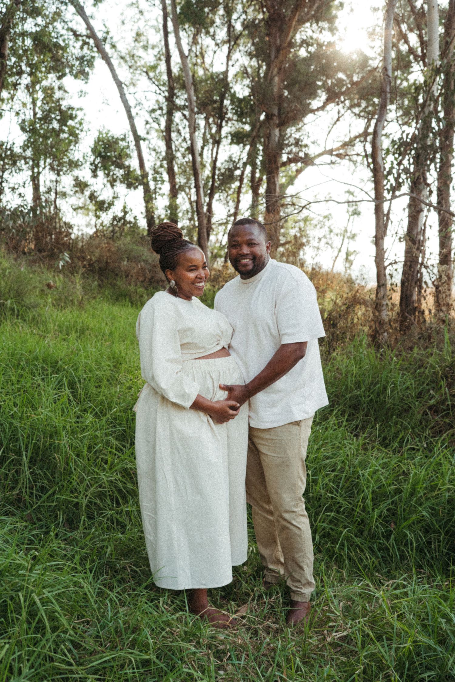 Loving couple in white outfits sharing a moment together in a natural outdoor setting.