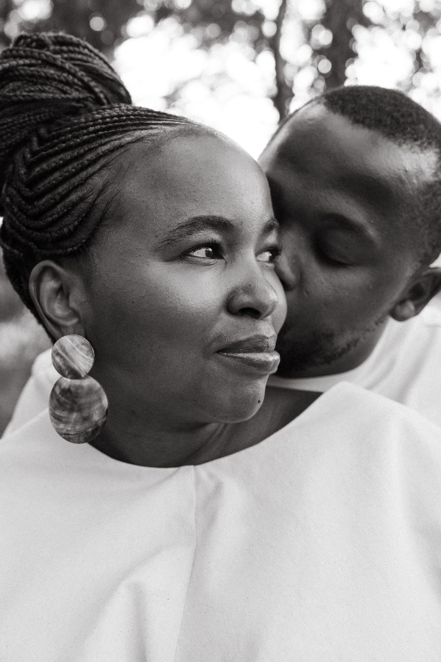 Close-up black and white portrait capturing an intimate moment between two people.