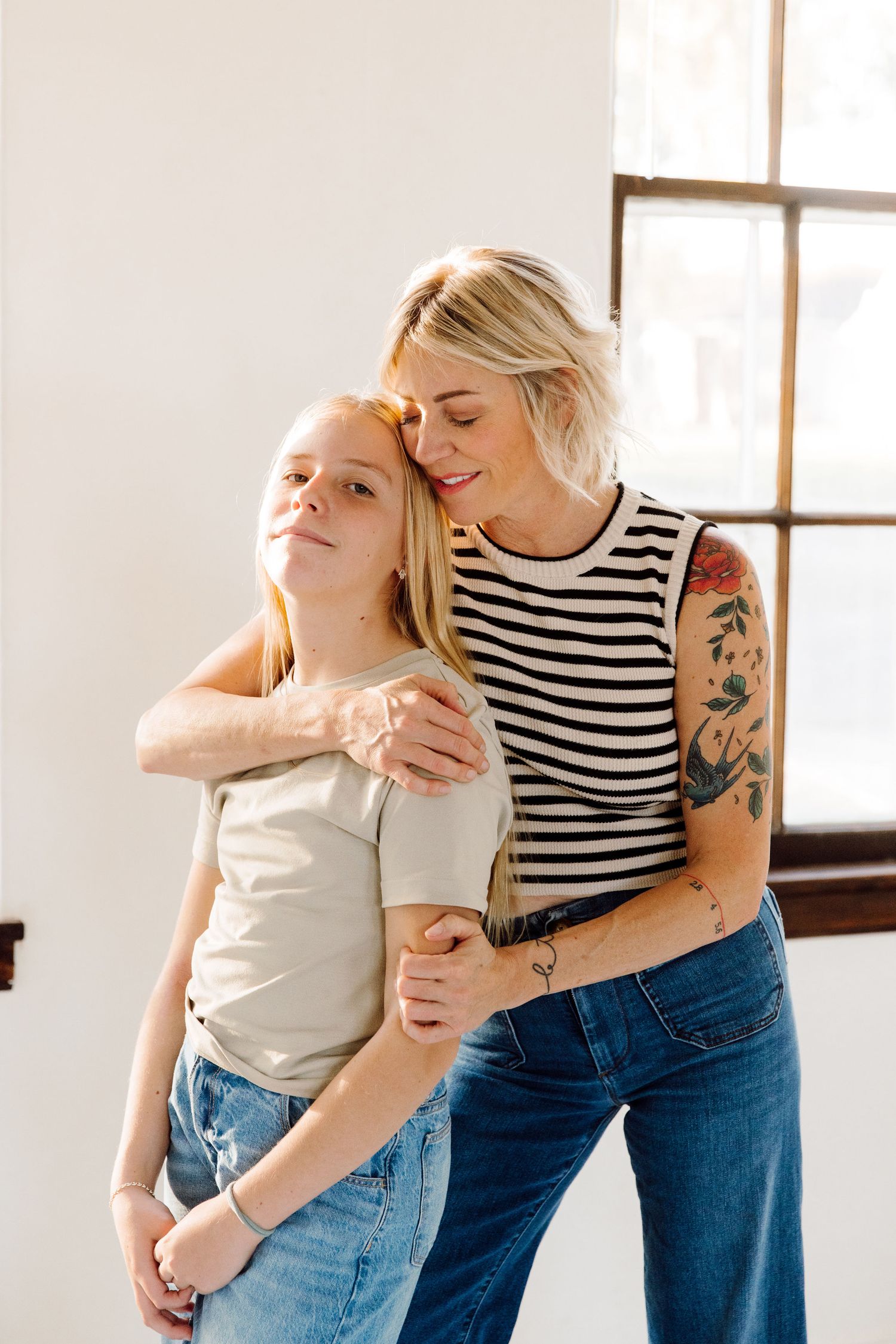 A parent and child share tender moments of affection and laughter in a bright, sunlit room.