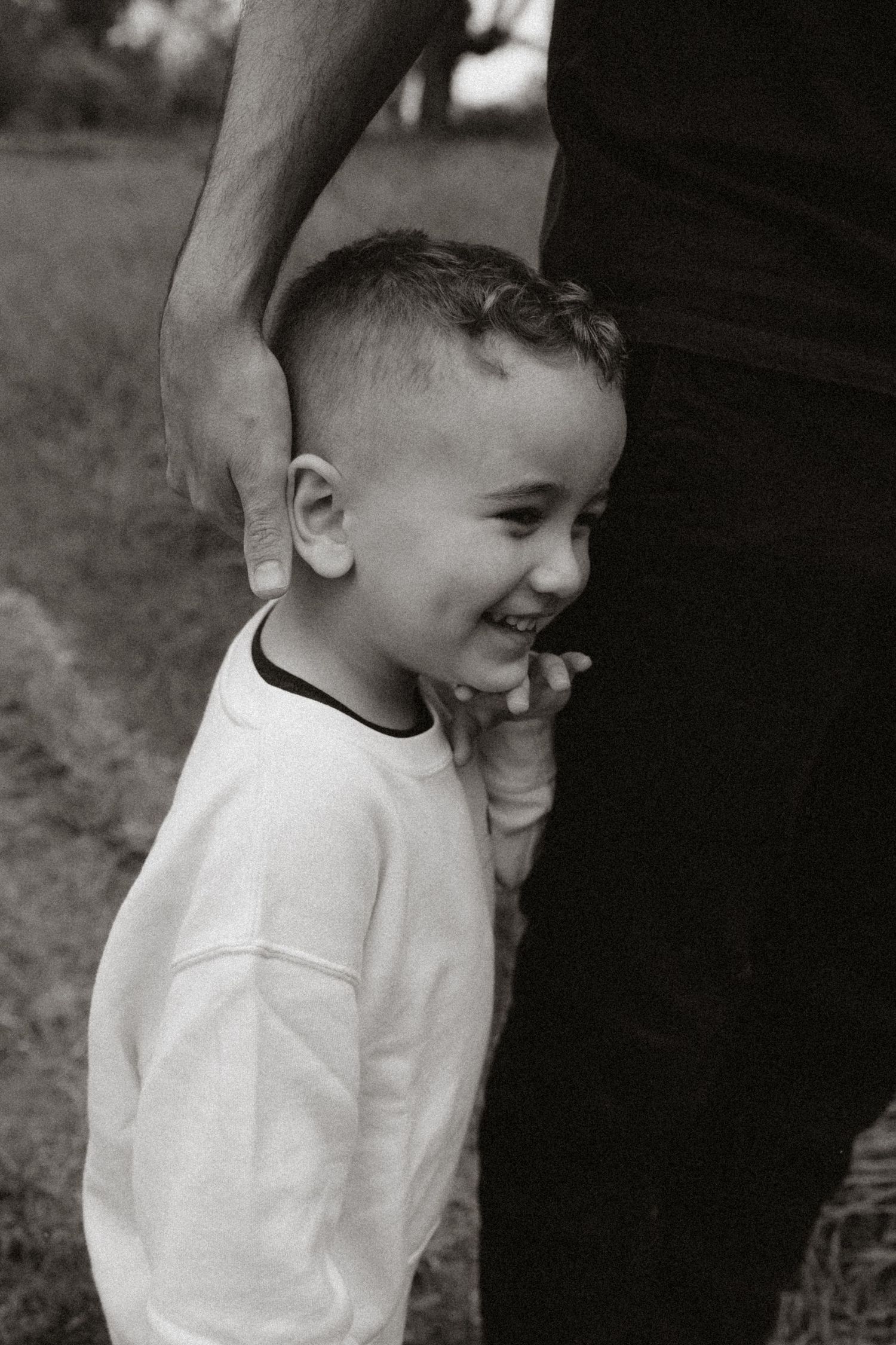 Joyful black and white sequence of a child laughing in casual attire.