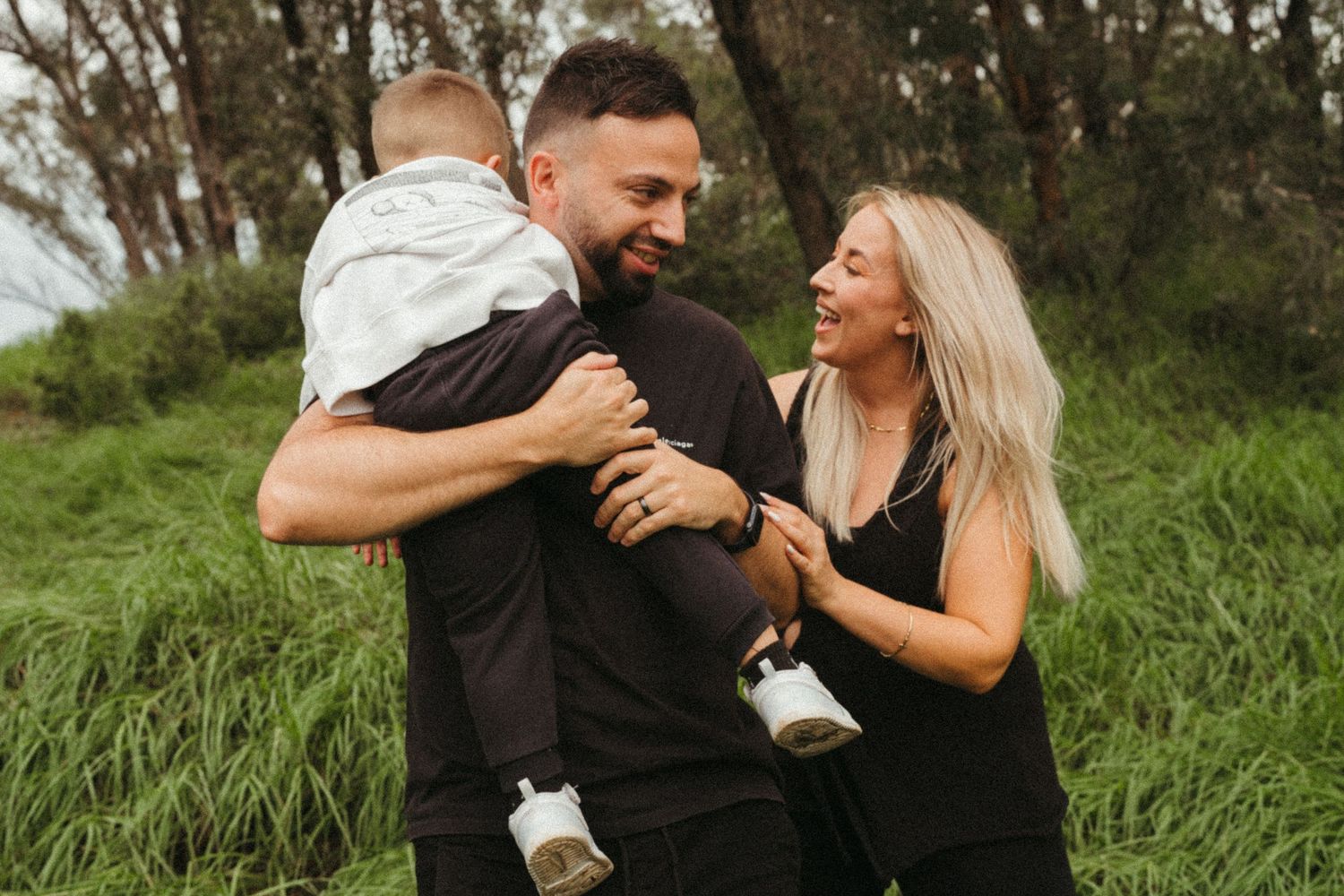 A couple embraces while laughing together during an outdoor photo session.