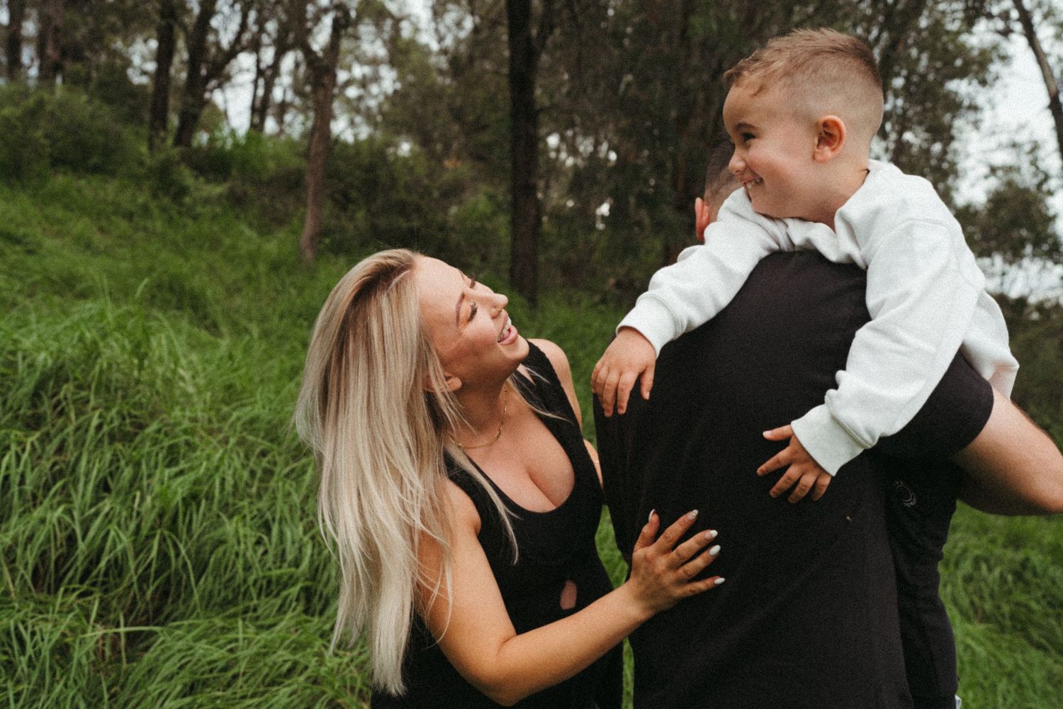 Two people in coordinated black and white outfits share a playful moment outdoors.