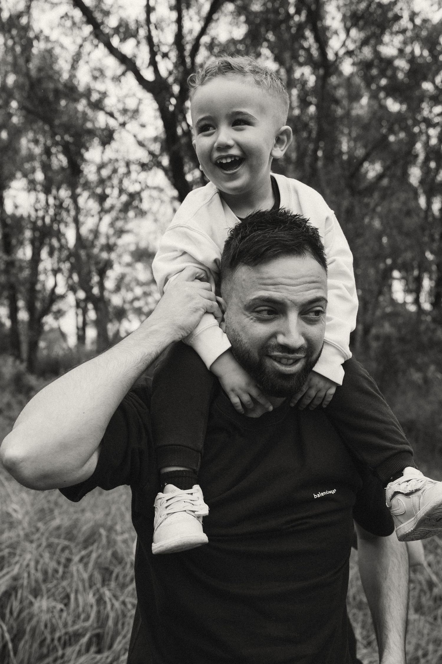 Black and white photo showing happy moments between parent and child outdoors.