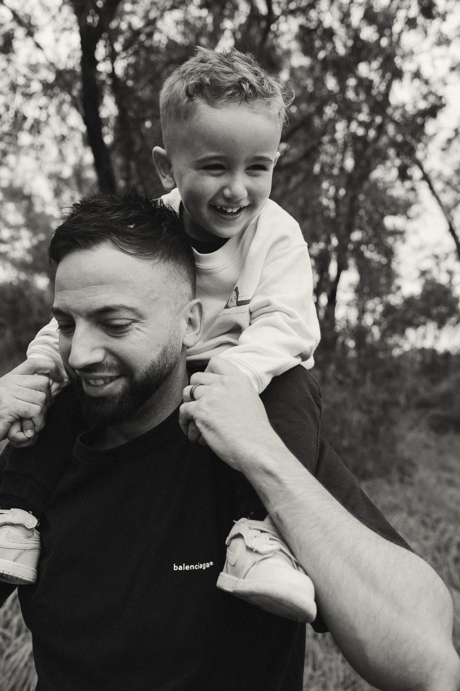 A playful black and white portrait showing joyful expressions and laughter in an outdoor setting.