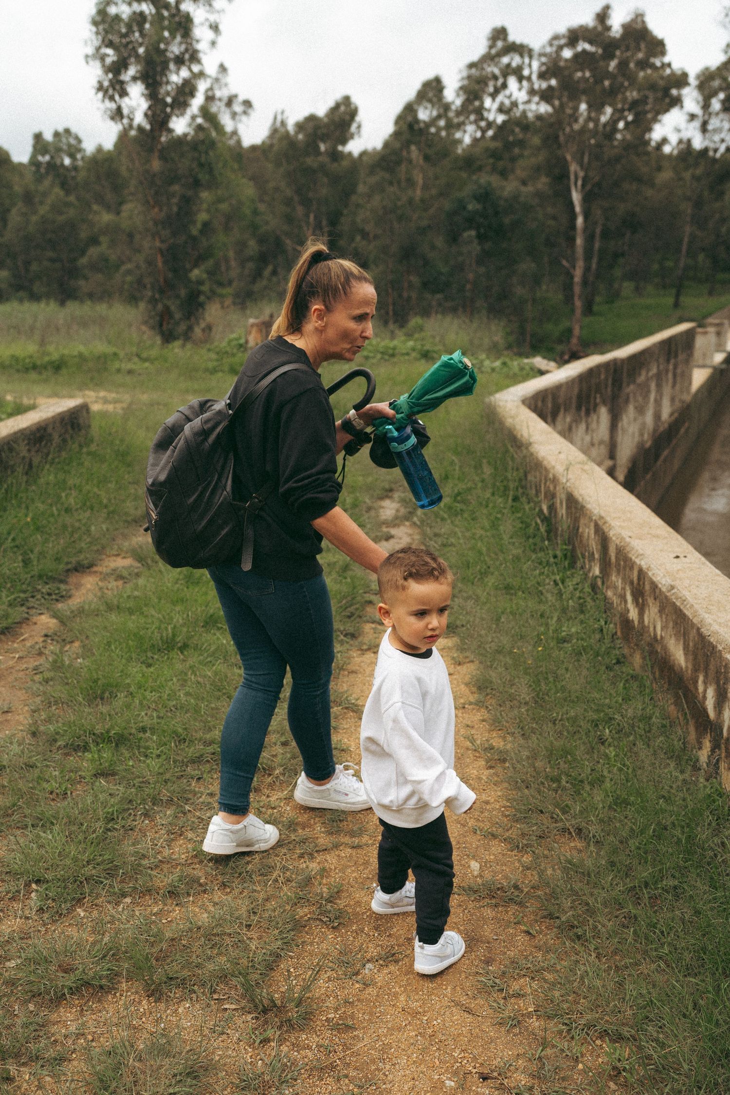People walking along a dirt path while playing and having fun outdoors.