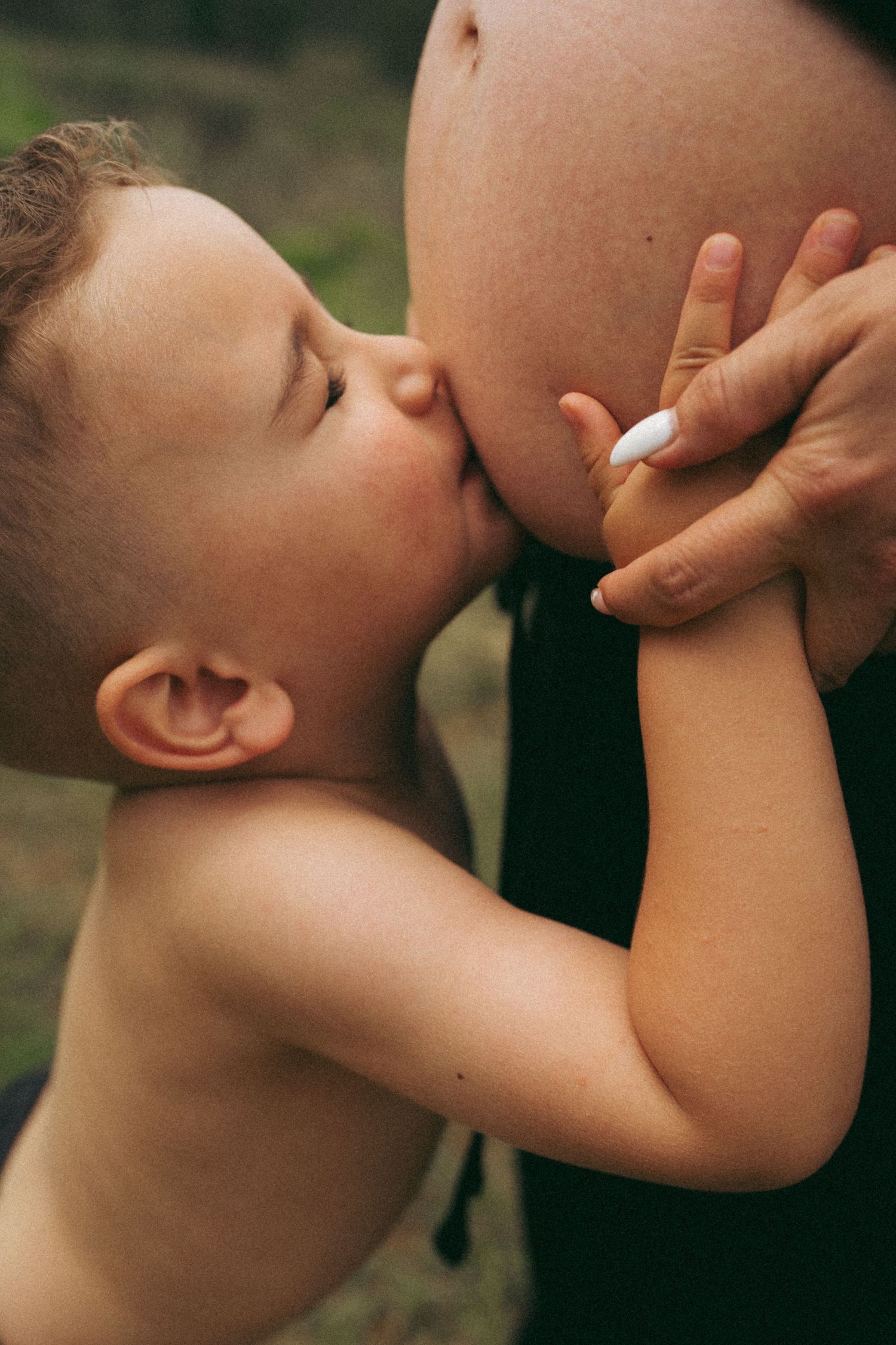 Close-up artistic series of a tender moment between parent and child in warm lighting.