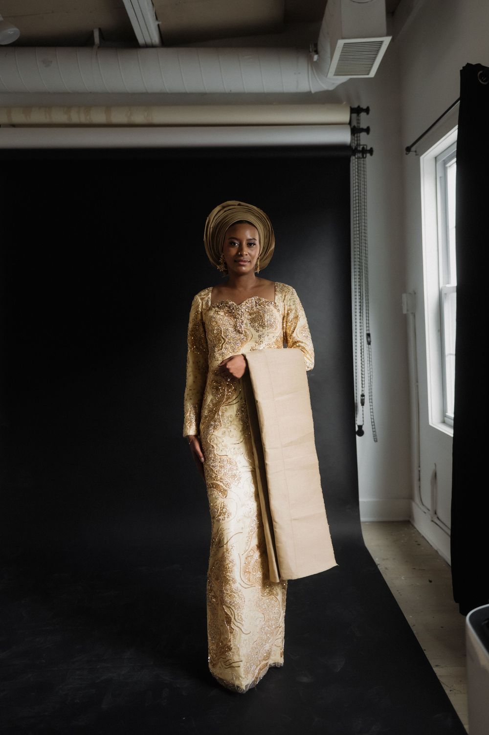 Fashion portrait series showing gold dress and traditional headwear in studio setting.
