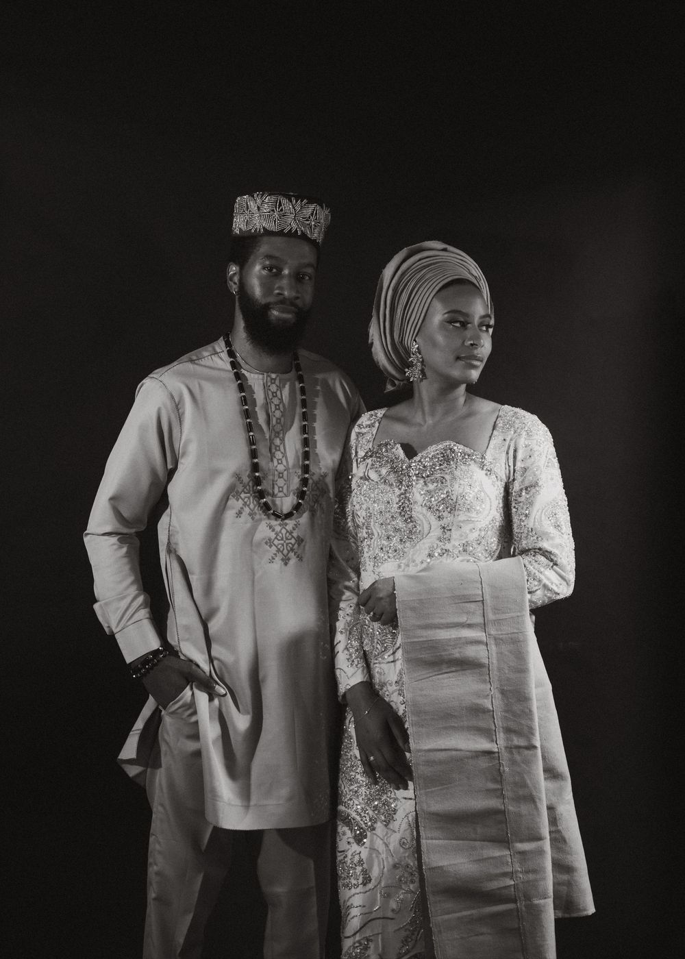 Artistic black and white portrait series showing traditional African-inspired formal attire against dark background.
