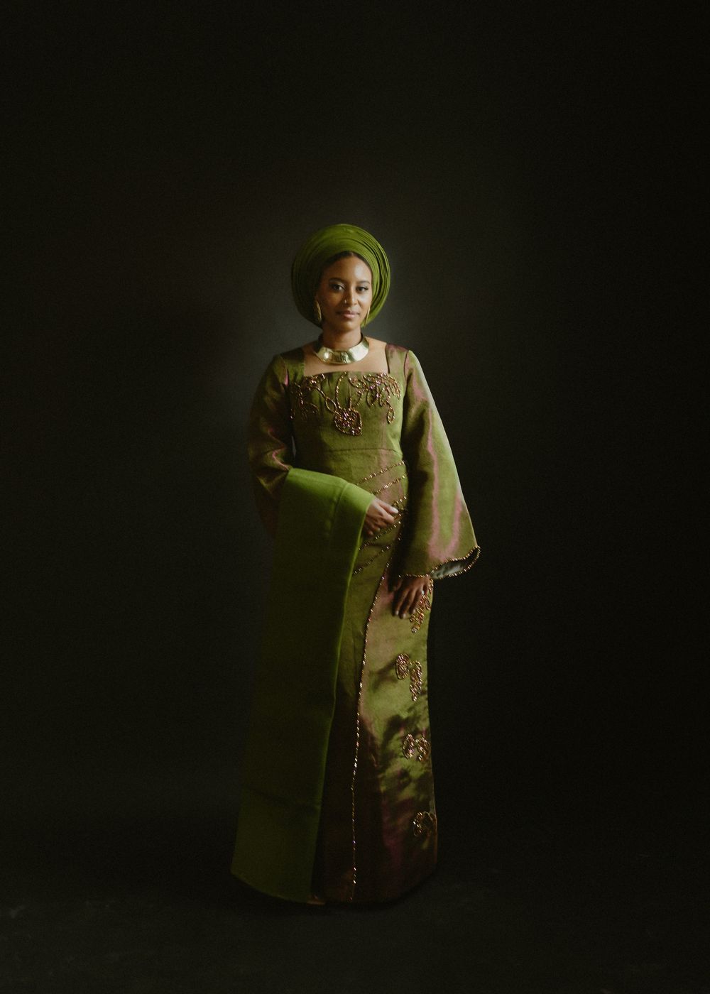 Dramatic portrait series featuring olive green traditional dress against dark background.