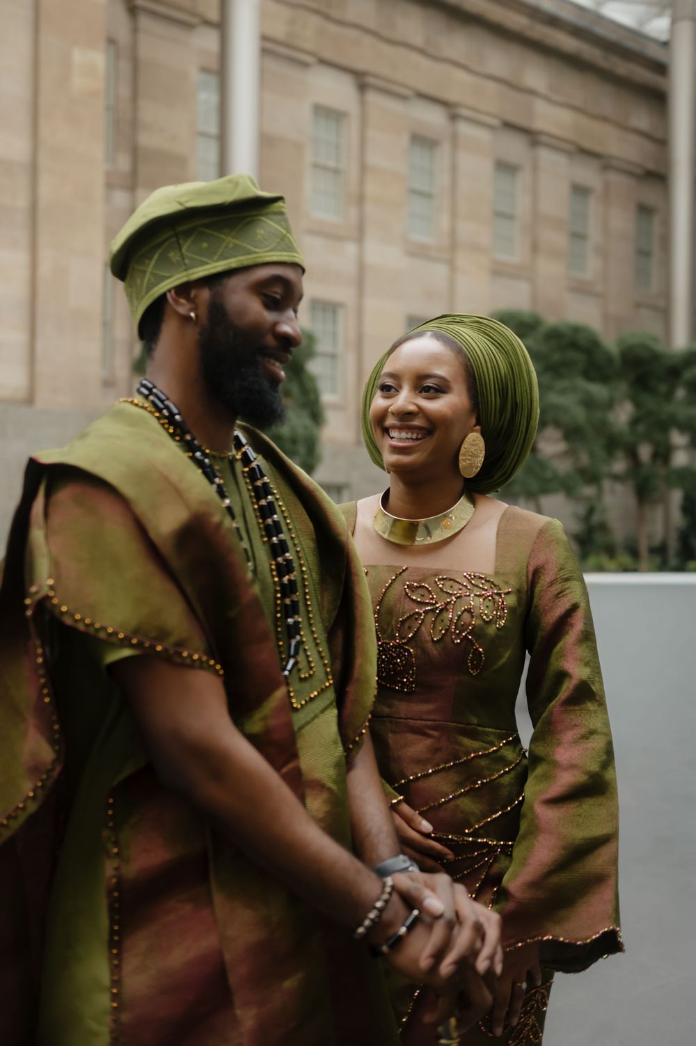 Candid moments captured in traditional green and gold attire outside stone building.