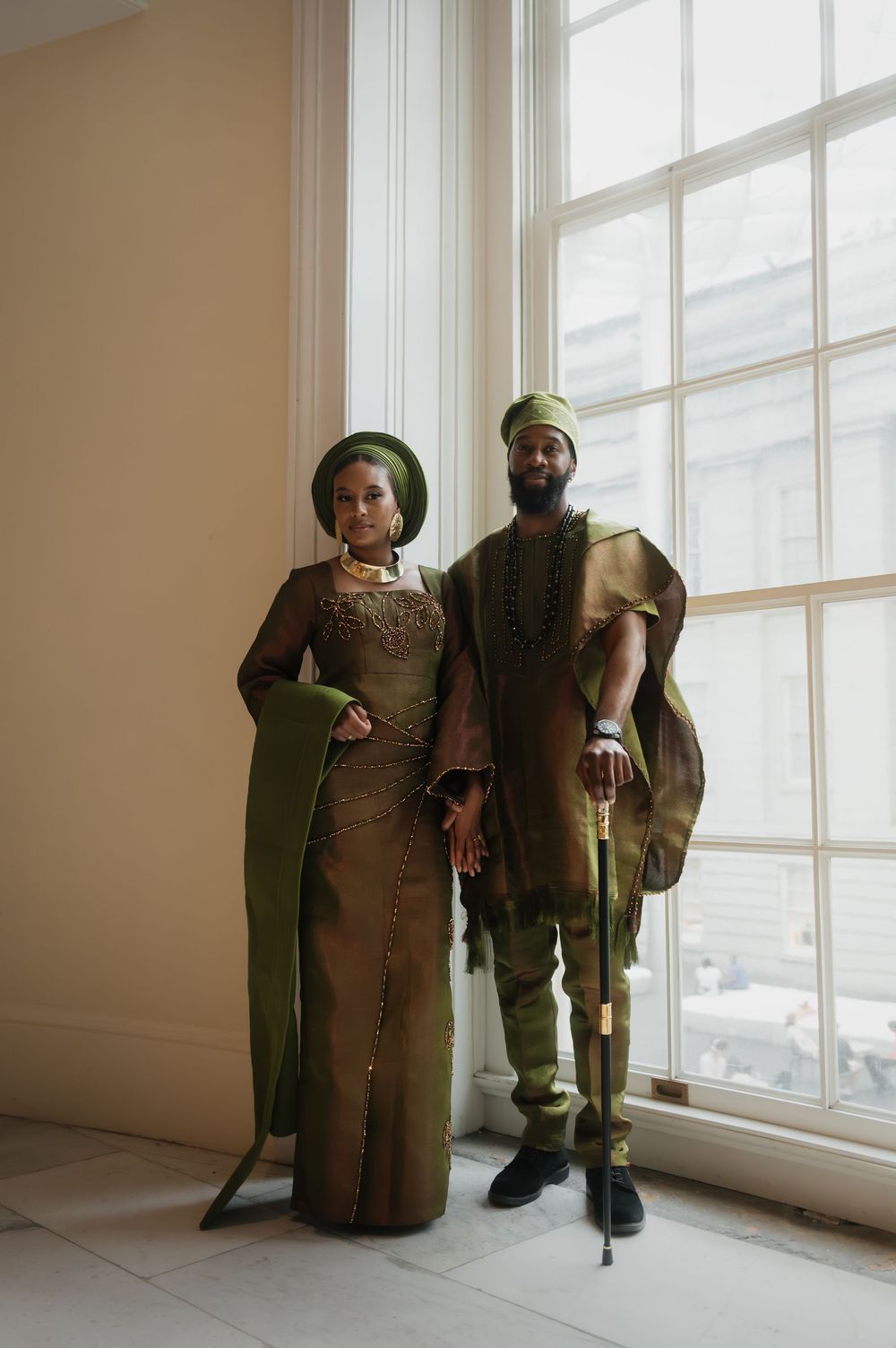 Indoor portrait series by window showing traditional olive and gold formal wear.