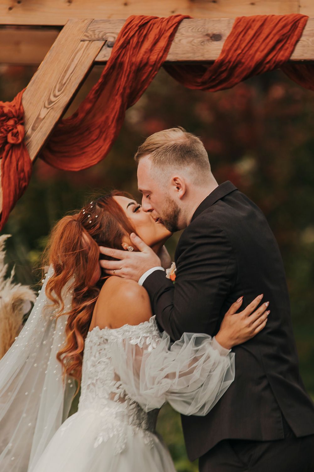 A romantic wedding couple shares intimate kisses in a series of outdoor portraits with autumn colors in the background.