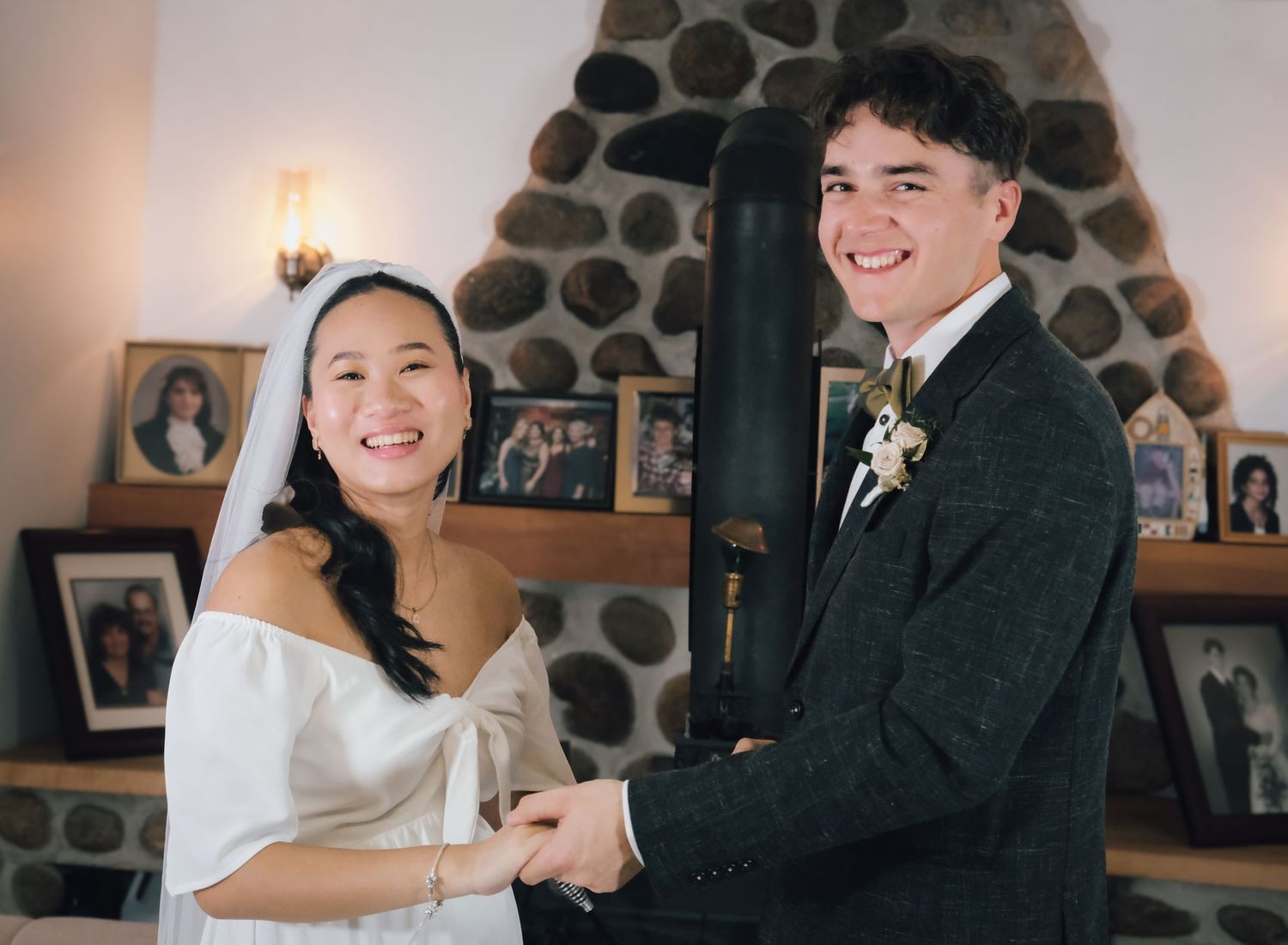 Wedding celebration in cozy interior with stone wall and warm lighting.