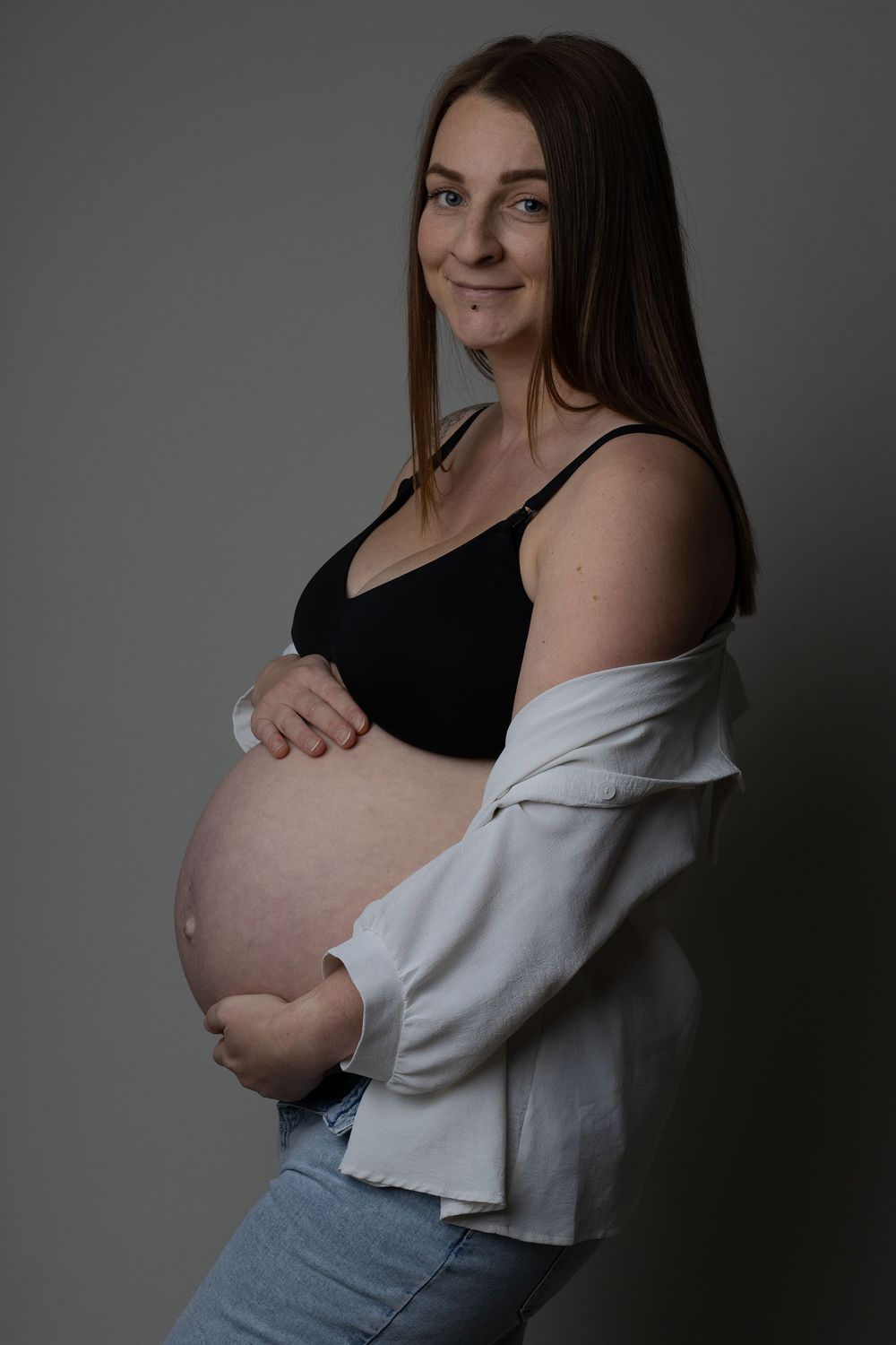 Expectant mother holding her baby bump during a maternity session with Ceredigion maternity photographer