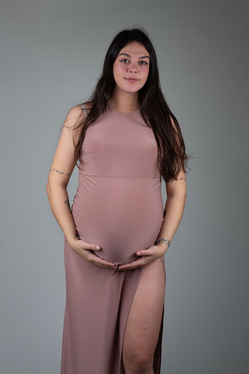Mother-to-be wearing a fitted pink dress during a maternity session in Ceredigion