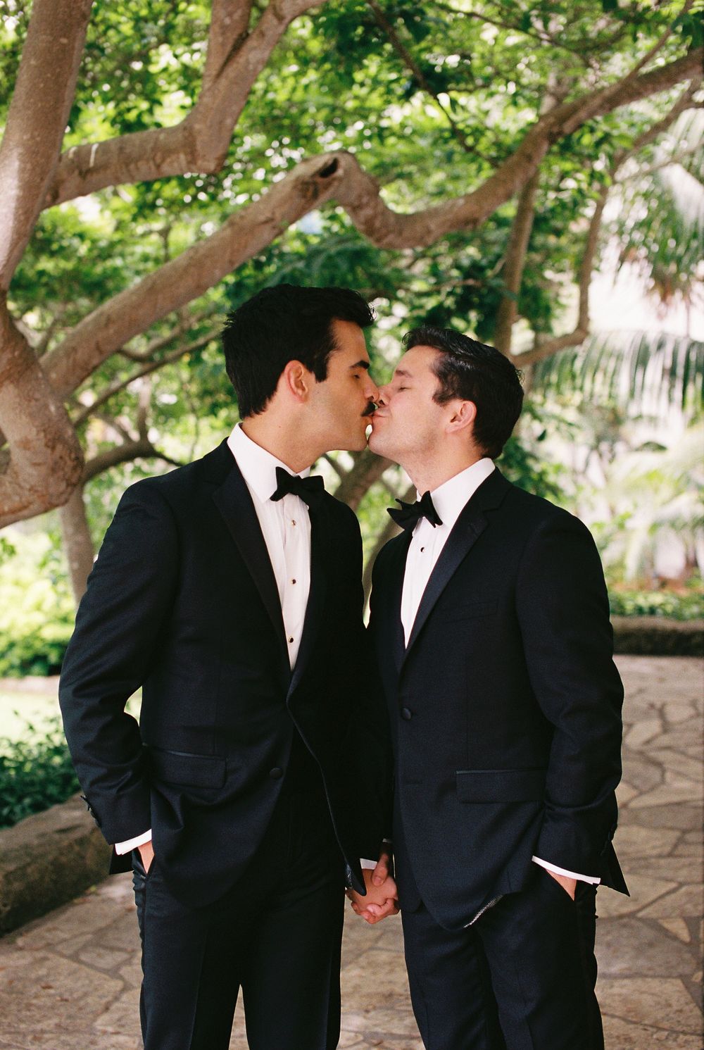 35mm film photo of two grooms from Louisiana sharing a kiss on Santa Barbara Courthouse grounds