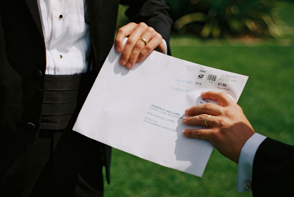 A photo on 35mm film showing two grooms holding their newly signed marriage license at the Santa Barbara Courthouse