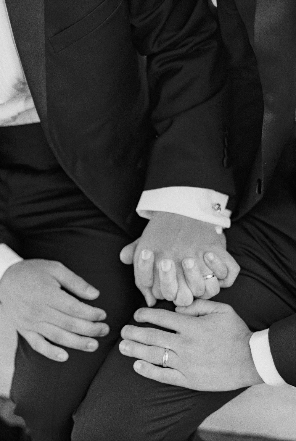 An artistic 35mm film black and white photo of two men showing off their wedding rings in Santa Barbara