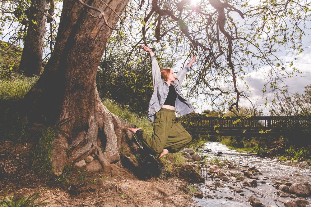 Sunlit outdoor photography session beneath large tree branches.