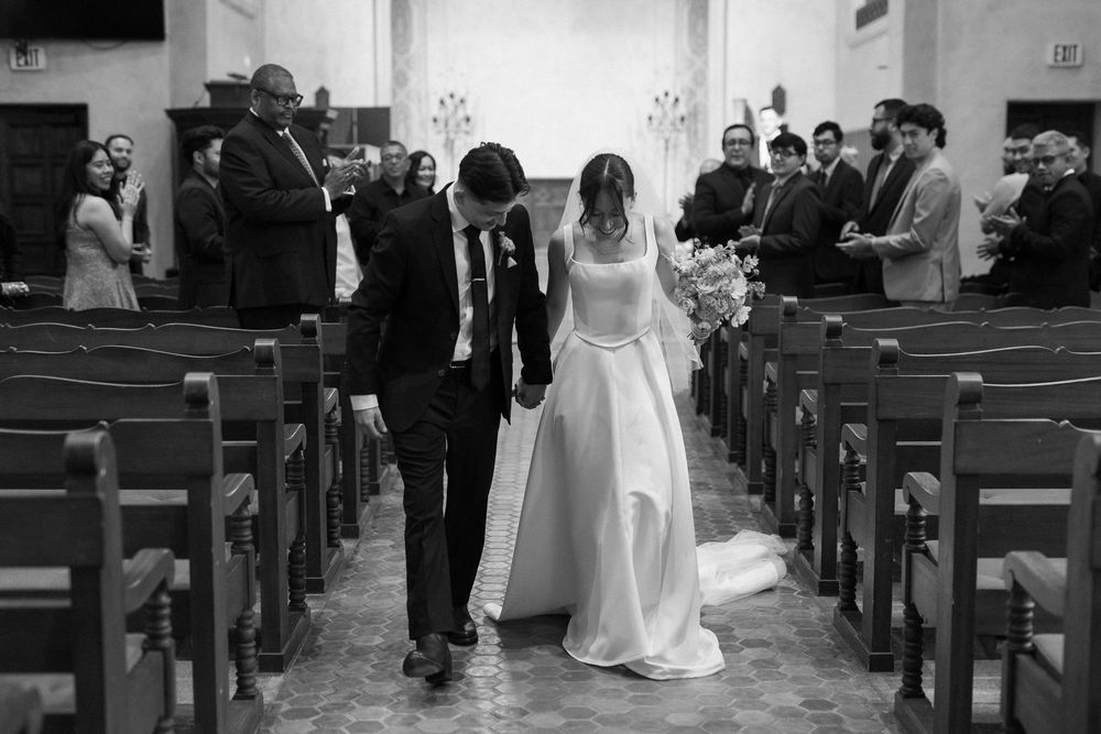 Digital photo of the newly married couple walking back down the aisle, beaming with joy.