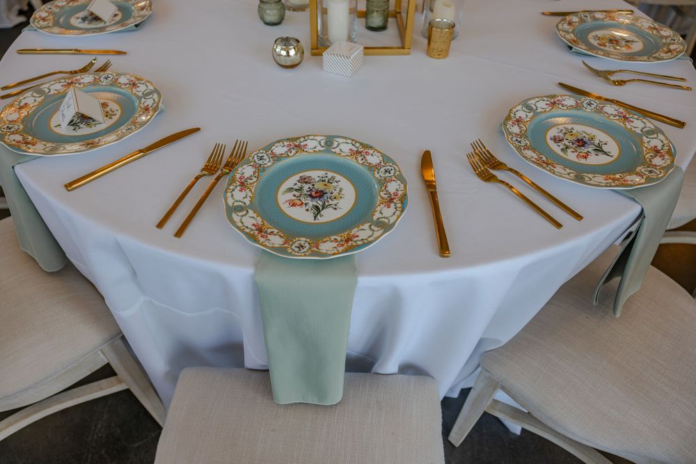 Elegant table settings with turquoise and gold plates arranged for a formal dining event.
