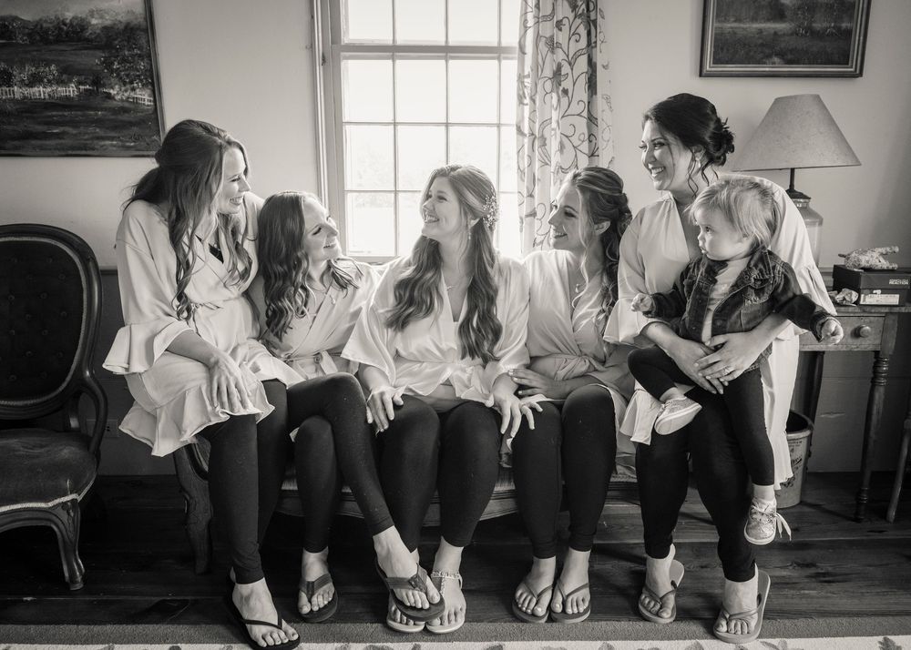 Black and white photo series showing bridesmaids sitting in a row displaying their matching shoes and dresses.