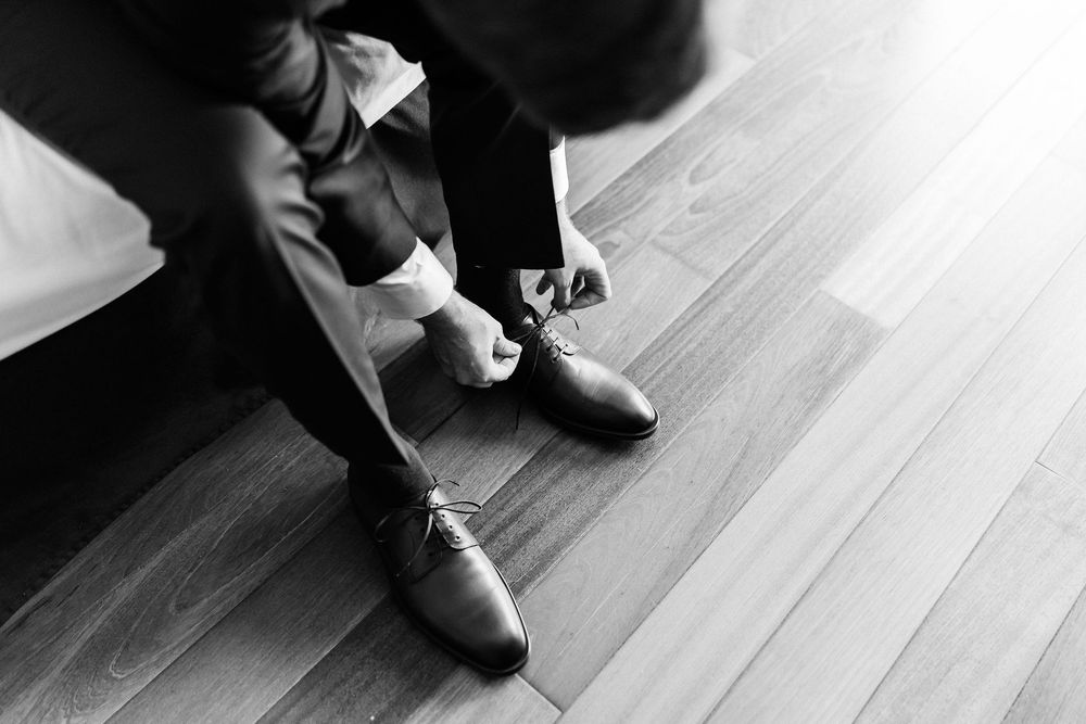 Black and white photo series showing close-up details of feet dancing on a wooden floor.