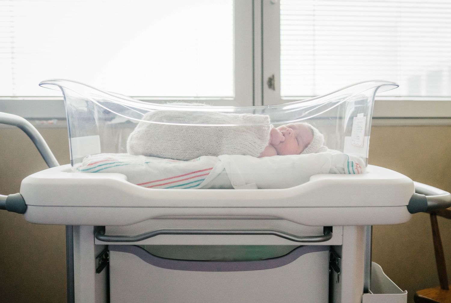 Newborn in bassinet in front of hospital window during fresh 48 session.