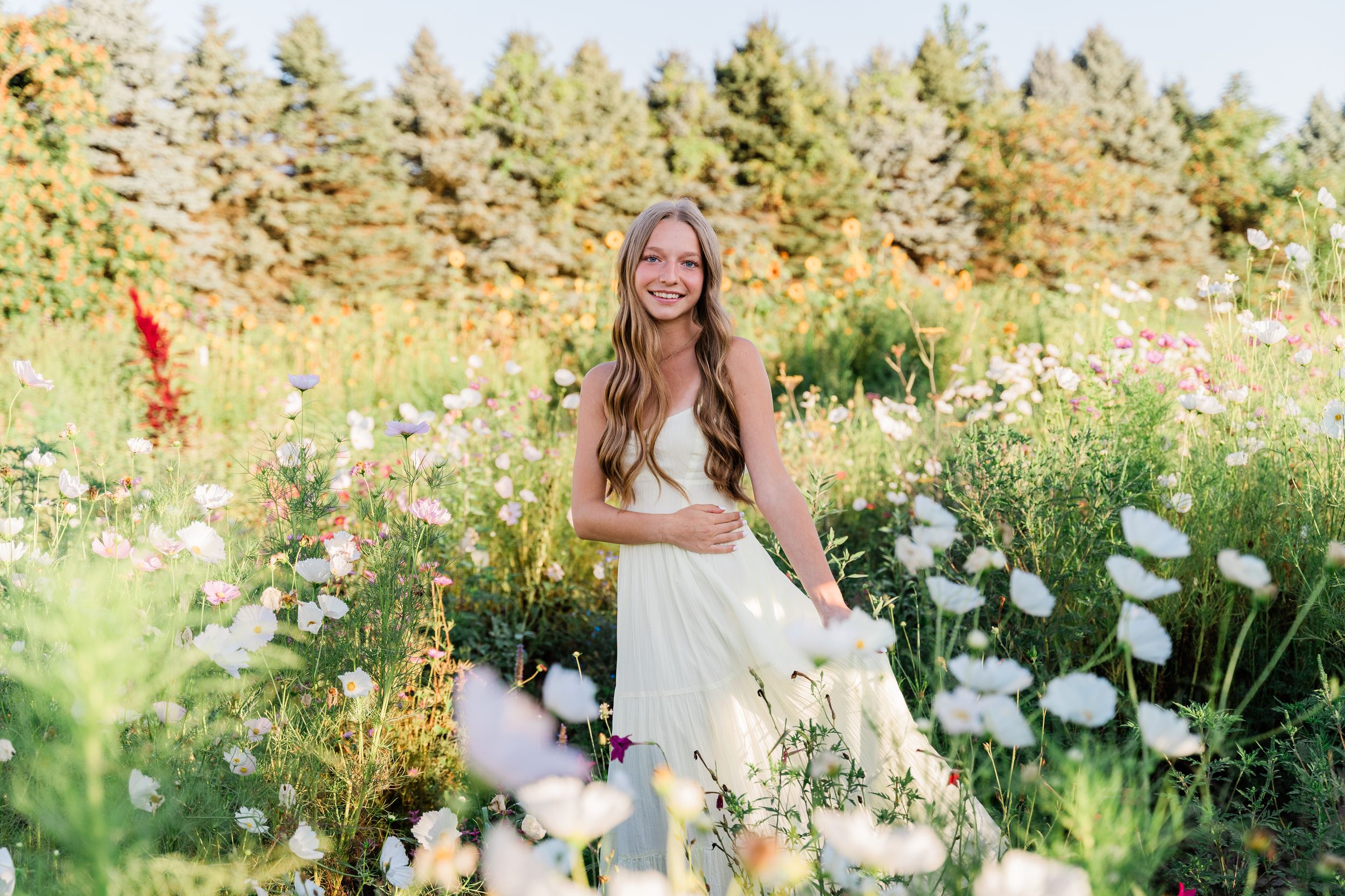 A collection of outdoor summer portraits featuring someone in a white dress surrounded by wildflowers and tall grass.