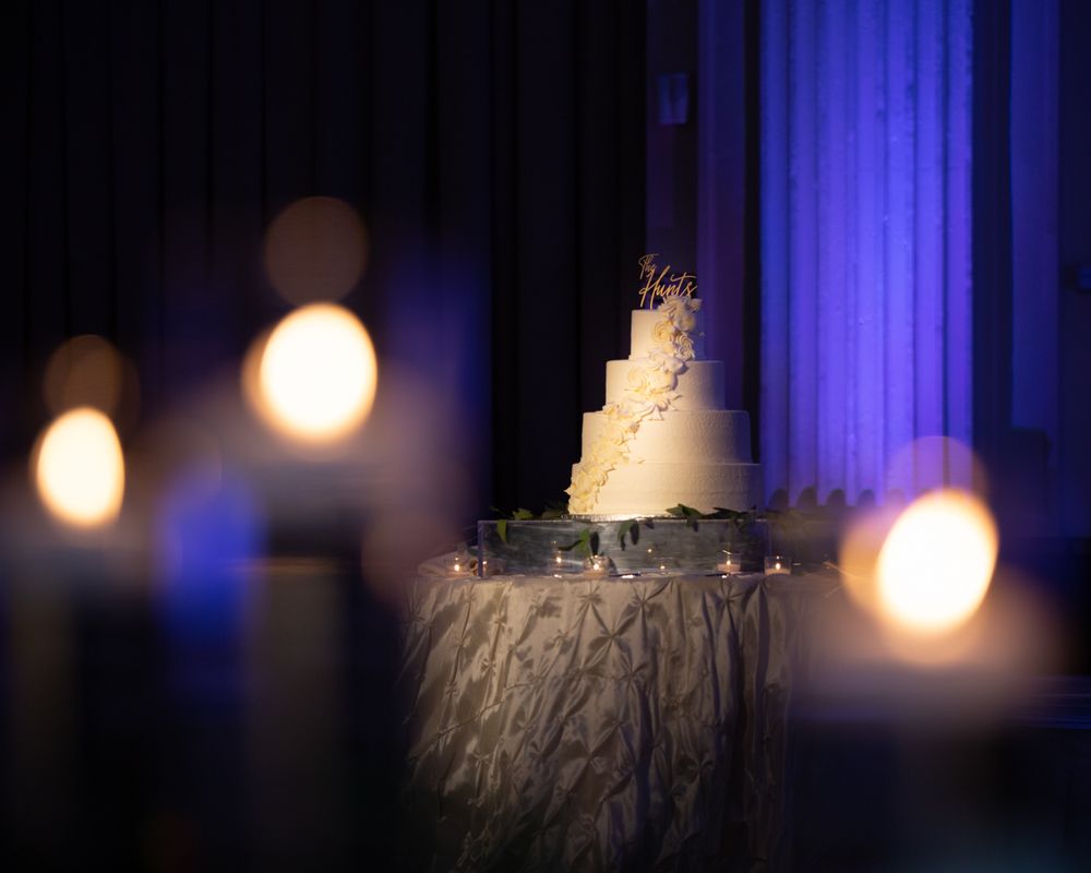 Artistic wedding reception venue lighting with blue uplights and ambient glowing orbs.