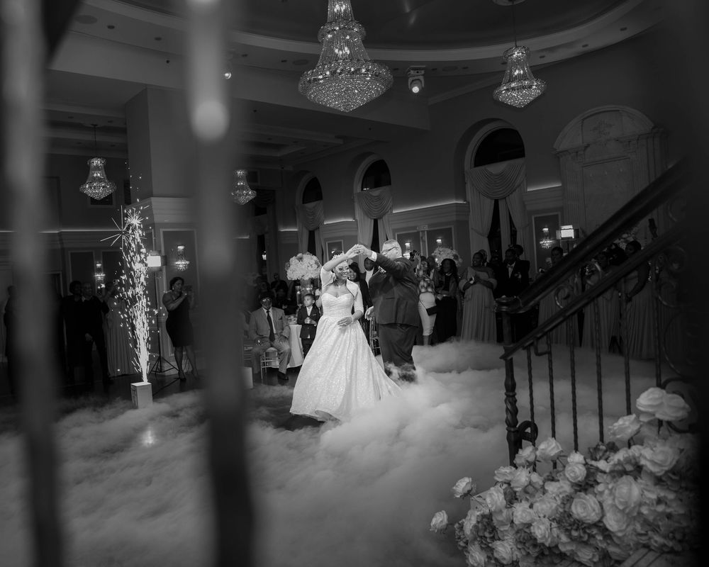 Wedding reception dance floor with fog effects and chandelier lighting.